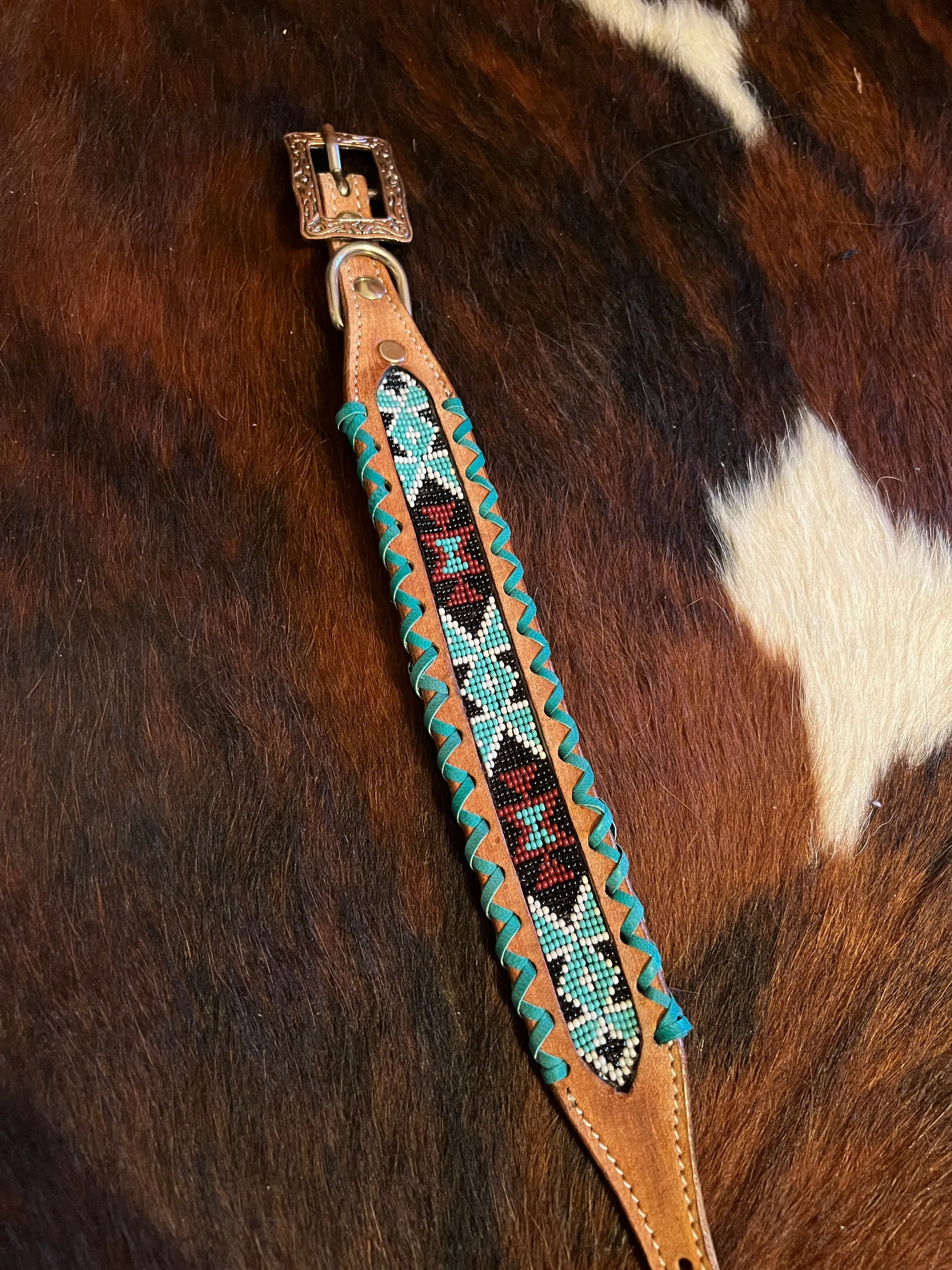 Genuine leather dog collar with teal, white, and burgundy navajo beaded inlay design, a rawhide wrapped edge